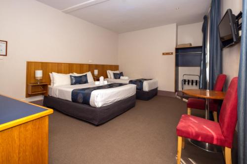 a hotel room with a bed and a pool table at Central Hotel Hobart in Hobart