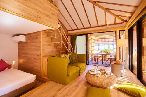 Habitación con cama, sofá y mesa. en Allamanda Imgya Coral Village en Isla Miyako
