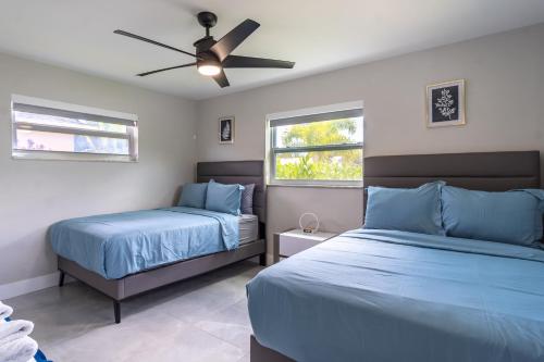 a bedroom with two beds and a ceiling fan at Hollywood Paradise Luxury 4BR 3BA Home and Outdoor Fun with Heated Pool in Hollywood