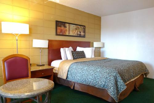 a hotel room with a bed and a table and a chair at Cabana Inn - Boise in Boise