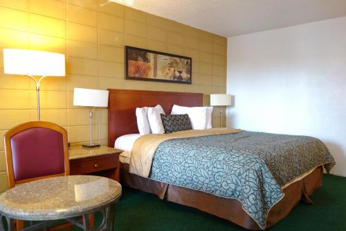 Habitación de hotel con cama, mesa y silla en Cabana Inn - Boise, en Boise
