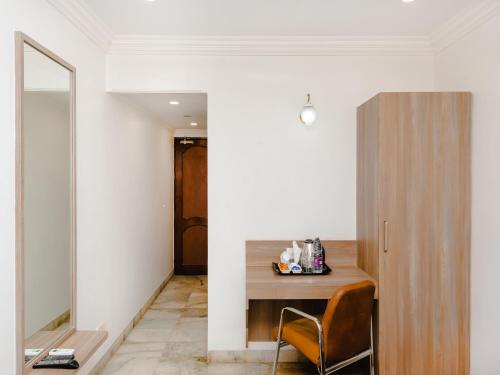 a room with a desk with a chair and a mirror at Hotel Galaxy Opp Surat Railway Station in Surat