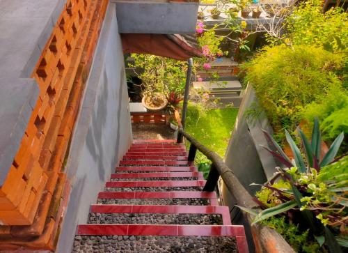 eine Treppe in einem Garten mit roten Stufen und Pflanzen in der Unterkunft Candra Asri Bungalow in Ubud