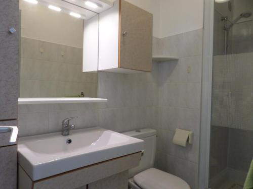 une salle de bain avec un lavabo, des toilettes et un miroir dans l'établissement Charmant 2 pièces rénové proche plage avec loggia vitrée, TV, local vélos et parking - FR-1-715-66, à Mauguio