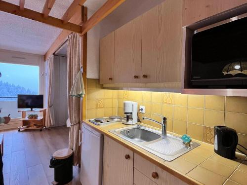 une cuisine avec un évier et un micro-ondes dans l'établissement Studio Spacieux 39m² Rénové avec Balcon, Garage, Équipements Bébé, Pied des Pistes à Villard-de-Lans - FR-1-515-166, à Villard-de-Lans