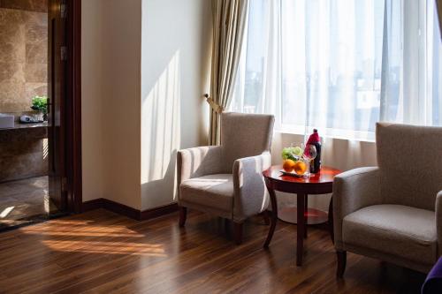 a room with chairs and a table and a window at Nesta Hotel Hanoi in Hanoi