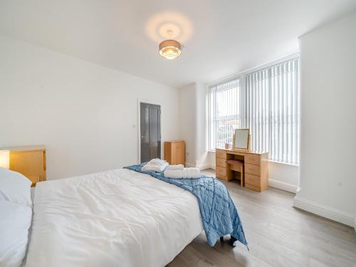 a white bedroom with a bed and a desk at Two - Uk43700 in Saint Annes on the Sea