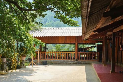 un edificio de madera con porche y valla de madera en A Hòa Homestay, en Ye Yen Sun Cay
