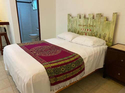 um quarto com uma cama com um cobertor em Villa Tortugas em Akumal