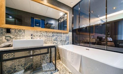 a bathroom with a large tub and a sink at Anseong Nomad Hotel in Anseong