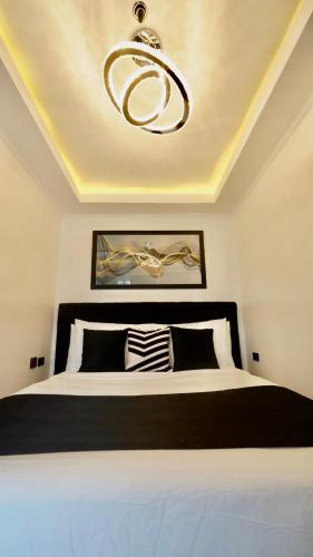 a bedroom with a black and white bed and a chandelier at MAKATI Isabela Luxury in Manila
