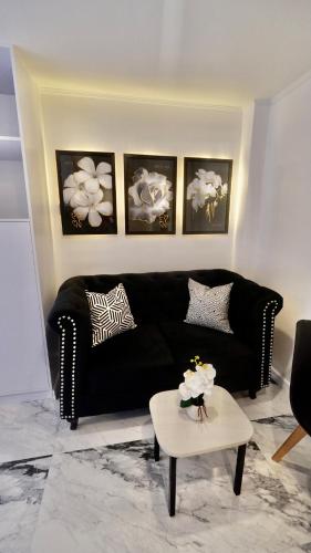 a living room with a black couch and a table at MAKATI Isabela Luxury in Manila