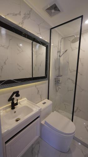 a white bathroom with a sink and a toilet at MAKATI Isabela Luxury in Manila