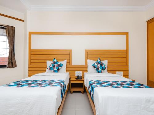 a bedroom with two beds and a window at Hotel Galaxy Opp Surat Railway Station in Surat