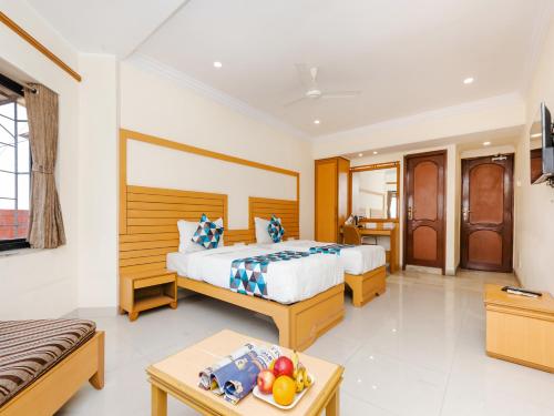 a hotel room with a bed and a table with fruit on the floor at Hotel Galaxy Opp Surat Railway Station in Surat