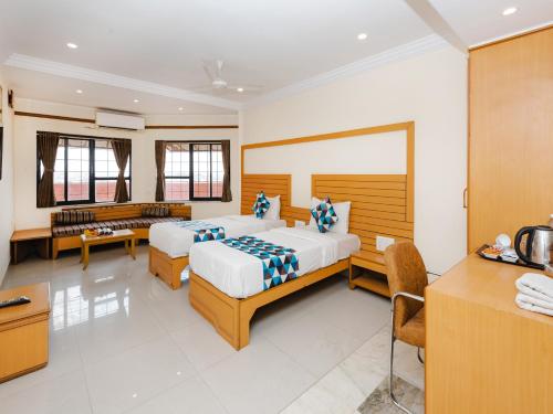 a hotel room with two beds and a desk at Hotel Galaxy Opp Surat Railway Station in Surat