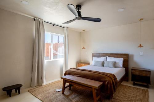 Schlafzimmer mit einem Bett und einem Deckenventilator in der Unterkunft Dt Jt Hot Tub Fire Pit Resort Feels in Joshua Tree
