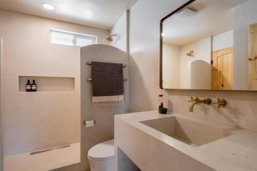 een badkamer met een wastafel, een toilet en een spiegel bij Dt Jt Hot Tub Fire Pit Resort Feels in Joshua Tree