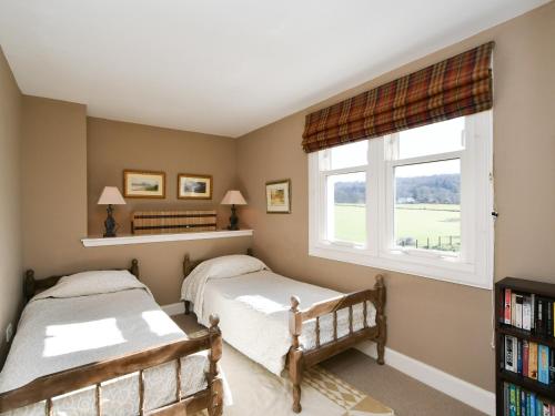 2 łóżka w sypialni z oknem w obiekcie Cliff Cottage w mieście Port Appin