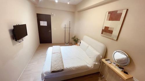 um quarto com uma cama branca e um espelho em 淳夏文旅民宿 第1310號 em Ch'ao-yang