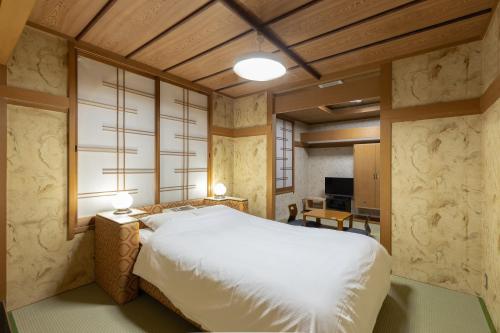 1 dormitorio con cama blanca y mesa en HOTEL Z23, en Tsu