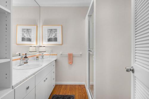 a white bathroom with two sinks and a shower at Lakefront House with Private Beach by Michigan Waterfront Luxury Properties in Norton Shores