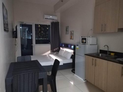 a small kitchen with a small bed in a room at SMDC Breeze Residences in Manila