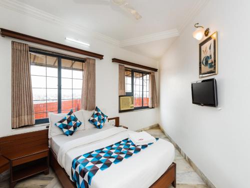 a bedroom with two beds and a tv at Hotel Galaxy Opp Surat Railway Station in Surat