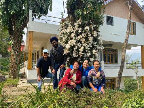 a group of people standing in front of a house at Bloomfield Farmhouse and Eco-Resort in Darjeeling