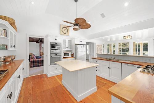 a kitchen with white cabinets and a ceiling fan at Glen Regan Berrima in Berrima