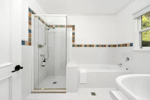 a white bathroom with a shower and a sink at Glen Regan Berrima in Berrima