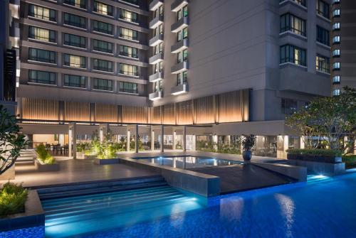 an exterior view of a building with a swimming pool at G Hotel Gurney in George Town