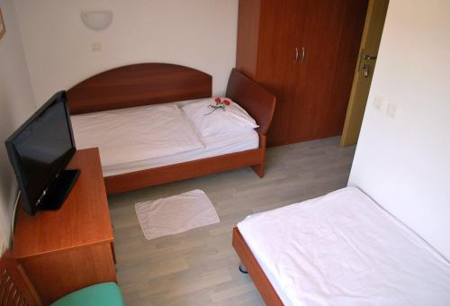 a small bedroom with a bed and a television at Bed and Breakfast Kogoj in Nova Gorica