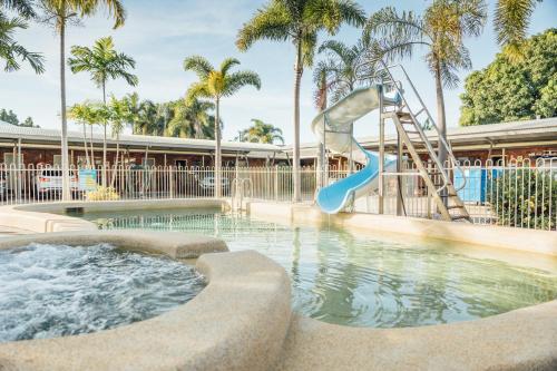 un tobogán de agua en un complejo con piscina en Billabong Lodge Motel en Townsville