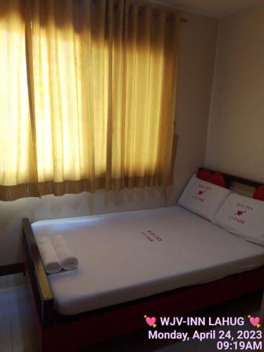 uma pequena cama num quarto com uma janela em WJV INN LAHUG em Tabok