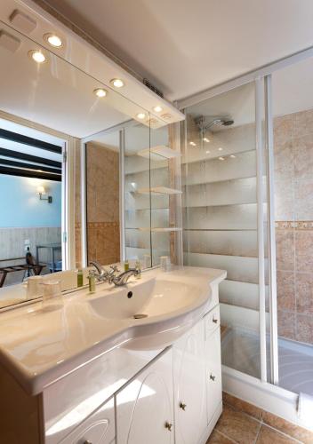 une salle de bain avec un lavabo et un grand miroir dans l'établissement Cit'Hotel Hôtel Beauséjour, à Cherbourg en Cotentin