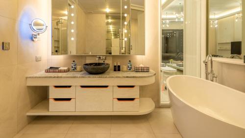 a bathroom with a tub and a sink and a bath tub at Sri Panwa Phuket Luxury Pool Villa Hotel - SHA Plus in Panwa Beach
