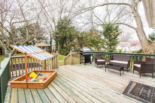 a deck with a grill and a table and chairs at Cozy getaway - 5 min drive to beach in Cape May