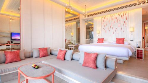 a bedroom with a large bed and two couches at Sri Panwa Phuket Luxury Pool Villa Hotel - SHA Plus in Panwa Beach