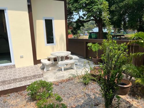 a patio with a picnic table and some plants at BSK Bungalows in Lipa Noi
