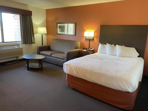 a hotel room with a bed and a couch at AmericInn by Wyndham Minocqua in Minocqua