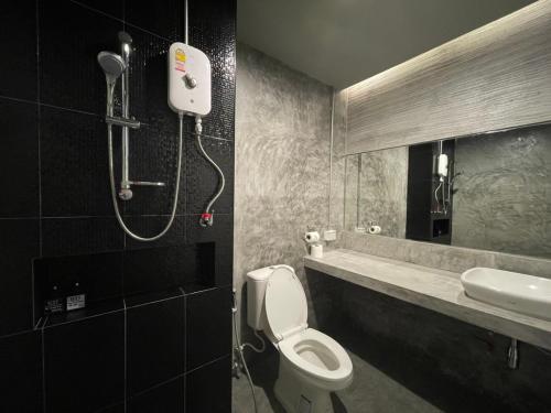 a bathroom with a shower and a toilet and a sink at Loft Space Hotel in Ranong