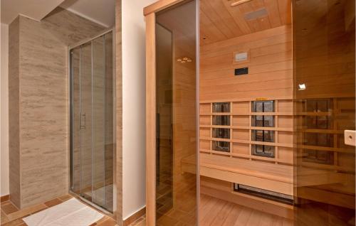 eine ebenerdige Dusche in einem Zimmer mit Holzwänden in der Unterkunft 4 Bedroom Awesome Home In Kosute in Košute