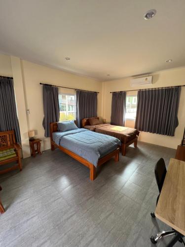 1 Schlafzimmer mit 2 Betten in einem Zimmer mit Fenstern in der Unterkunft BSK Bungalows in Lipa Noi