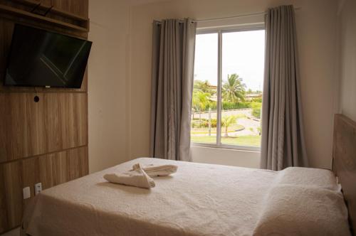 a hotel room with a bed with two towels on it at Apartamento na Reserva Imbassai in Imbassai