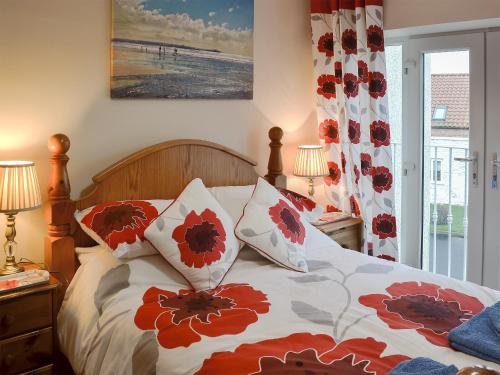 ブリドリントンにあるMeadow Viewのベッドルーム1室(赤と白の枕が備わるベッド1台付)