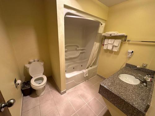 a bathroom with a toilet and a sink and a shower at Super 8 by Wyndham Colby in Colby