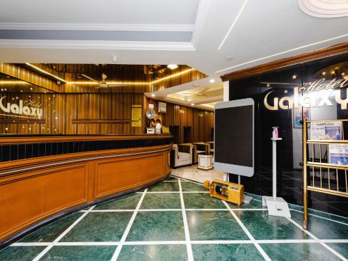 een lobby met een bar en een flatscreen-tv bij Hotel Galaxy Opp Surat Railway Station in Surat
