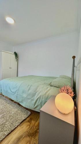 um quarto com uma cama e uma mesa com uma tigela em Cozy home in a peaceful area em Hayes