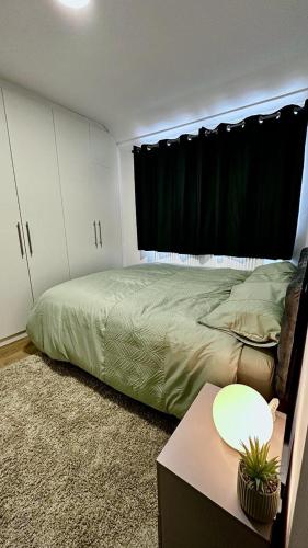 um quarto com uma cama verde e uma janela em Cozy home in a peaceful area em Hayes
